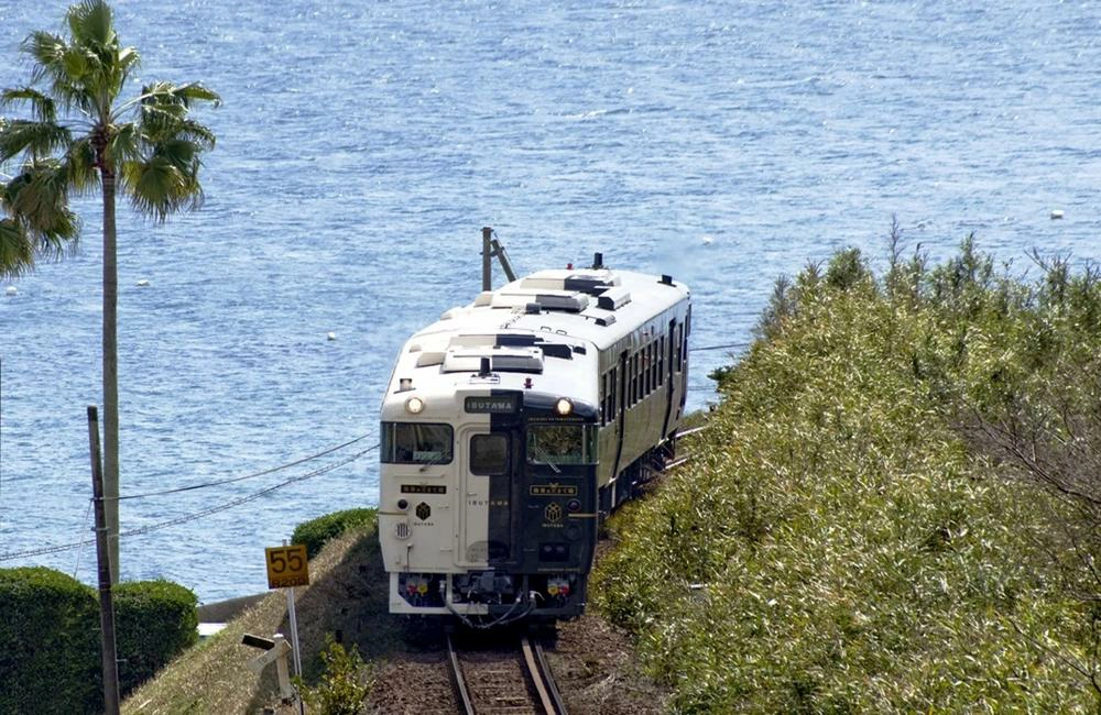列車窗景與黑白車體映照海灣