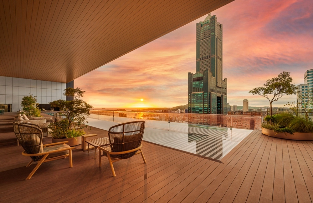 SEVENTEEN小分隊cxm演唱會高雄開唱懶人包整理 - Travel x Freedom 旅誌字遊 threeonelee.com 高雄市區高空露台景觀,戶外座椅面向港灣與城市天際線,夕陽映照飯店公共空間的實際場景